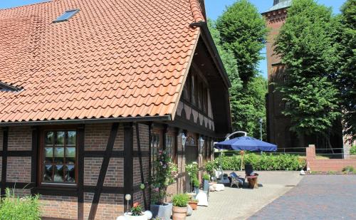 a building with an orange roof with an umbrella at ferienwohnungen-deichgraf in Loxstedt