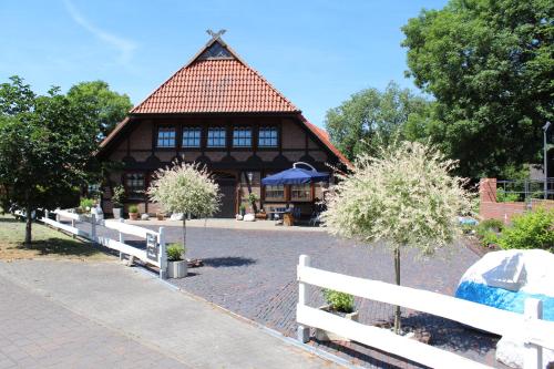 Loxstedtにあるferienwohnungen-deichgrafの塀と木の屋根の建物