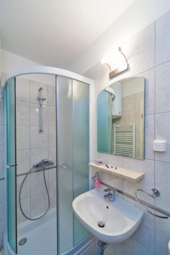a bathroom with a glass shower and a sink at Apartments Marija Lapad in Dubrovnik