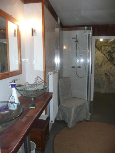 een badkamer met een douche, een wastafel en een stoel bij 81 Rue des Juifs in Granville