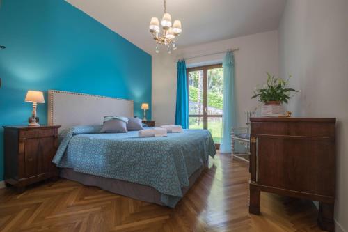 una camera blu con un letto e una finestra di La Punta Apartment a Bellagio