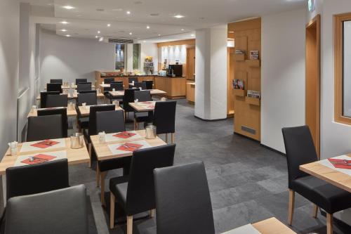 a dining room with tables and chairs at City Hotel in Luxembourg