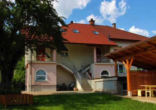 una casa con techo rojo y escalera en Prenočišča Angelin hram, Tiny Apartments, en Markovec
