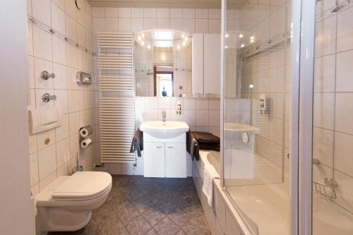 a bathroom with a toilet and a sink and a shower at Hotel Löwen in Reit im Winkl