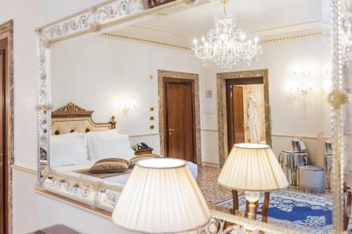 a bedroom with a large mirror and two lamps at Hotel Ai Cavalieri di Venezia in Venice