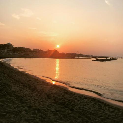 a sunset on the beach with the sun setting at Hotel Boom in Rimini