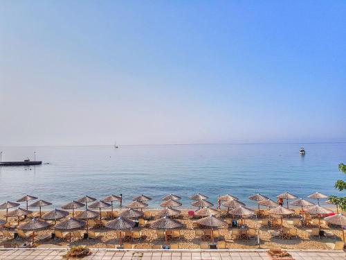 a group of umbrellas and chairs on a beach at Menios Apartments and Studios in Nea Kalikratia