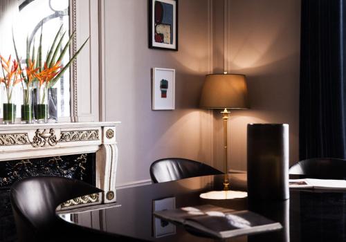 a room with a table and chairs and a fireplace at Hôtel Vernet Champs Elysées Paris in Paris