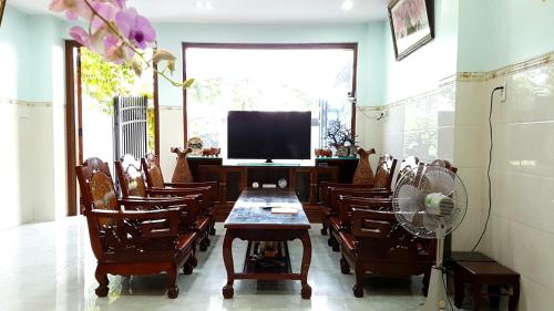 ein Esszimmer mit einem Tisch, Stühlen und einem Ventilator in der Unterkunft Phat Dat Hotel in Quảng Ngãi