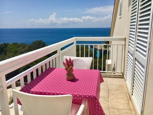 a pink chair sitting on top of a beach next to a balcony at Apartments Marija Magdalena in Hvar