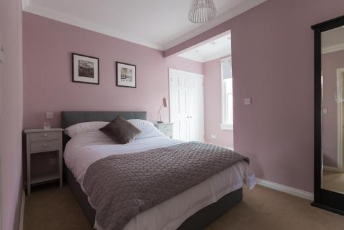 ein Schlafzimmer mit einem großen Bett und einem Spiegel in der Unterkunft Vesta Central Bath Apartment in Bath