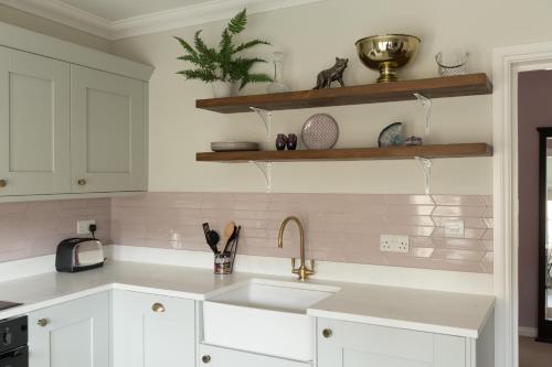 eine Küche mit weißen Schränken und einer Spüle in der Unterkunft Vesta Central Bath Apartment in Bath