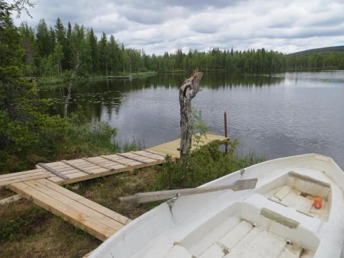 a boat sitting next to a dock on a lake at Toola-Lodge in Syöte
