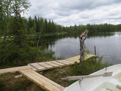 a dock on the side of a lake with a boat at Toola-Lodge in Syöte