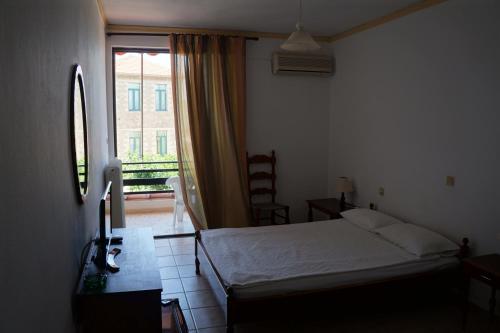 a bedroom with a bed and a large window at Lemonies in Diakopto