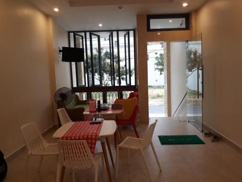 a dining room with a table and chairs and a window at Tabii hotel in Da Nang