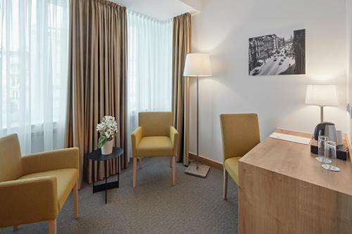 a room with chairs and a table in a hotel room at City Hotel in Luxembourg