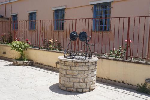 a statue of a hat on top of a brick pillar at Lemonies in Diakopto