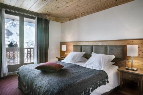 sypialnia z łóżkiem i widokiem na góry w obiekcie Hôtel Saint-Martin w mieście Saint-Martin-de-Belleville