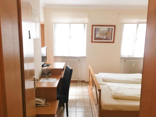 a small room with a desk and a bed at Pension Mona Lisa in Munich