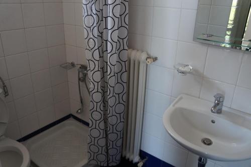 a bathroom with a shower curtain next to a sink at Lemonies in Diakopto