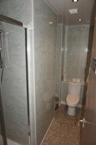 a bathroom with a toilet and a glass shower stall at The Boundary Hotel - B&B in Leeds