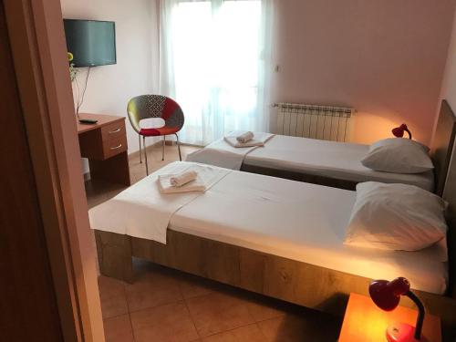 two beds in a room with a desk and a chair at Guest House Ivo in Split