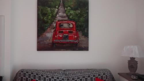 uma pintura de um carro vermelho dirigindo por uma estrada em Victoria em Calvi