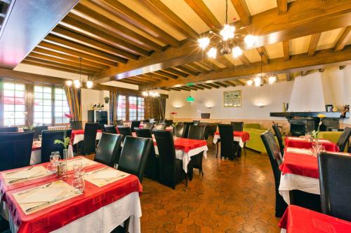 a restaurant with red and black tables and chairs at Logis Hôtel de la Paix in Saint-Nectaire