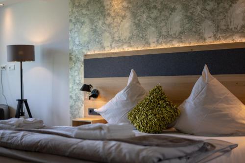 a bedroom with a bed with pillows at Boutiquehotel Genusswerk Eifel in Körperich