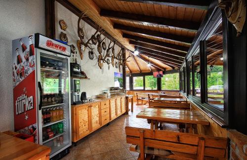 a restaurant with wooden tables and a refrigerator at Guest House Spoljaric Sasa in Rastovača