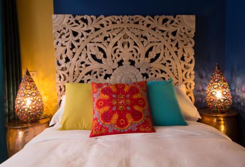 a bedroom with a white bed with colorful pillows at St.Michaels Bistro in Painswick