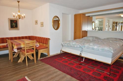 a bedroom with a bed and a table and a dining room at Studio Willimann Haus Dala im 4 Stock in Leukerbad