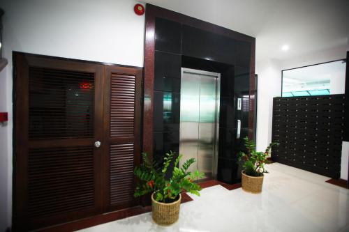 a lobby with two potted plants in front of a door at Pattara Place in Chiang Mai