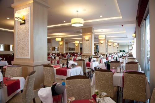 a dining room with tables and chairs in a restaurant at Merve Sun Hotel & SPA in Side