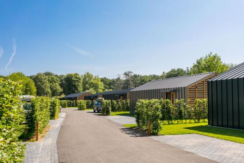 a man standing in a garden next to a building at Suitelodges Gooilanden in Loosdrecht