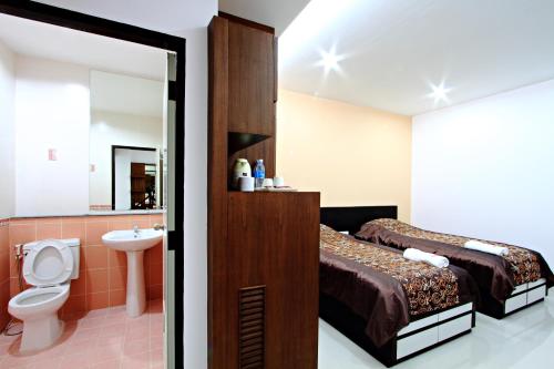 een badkamer met een bed, een toilet en een wastafel bij Pattara Place in Chiang Mai
