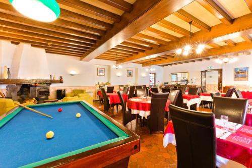- un billard dans un restaurant avec des tables et des chaises dans l'établissement Logis Hôtel de la Paix, à Saint-Nectaire