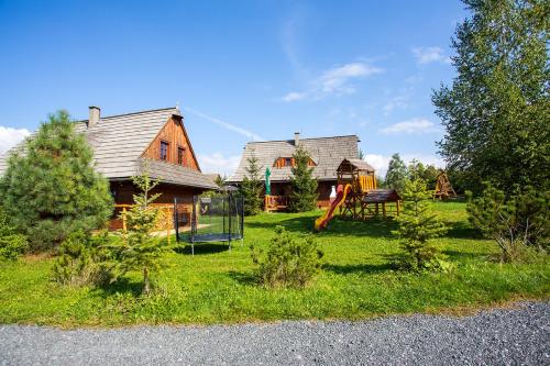 un patio con una casa y un parque infantil en Rekreačné chalupy, en Liptovský Trnovec