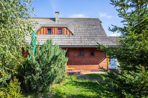 a wooden house with a gambrel roof at Rekreačné chalupy in Liptovský Trnovec