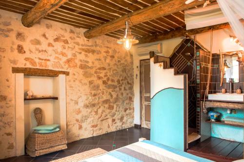 a bedroom with a bed in a room with a stone wall at B&B Le Manoir De Gemenos in Gémenos