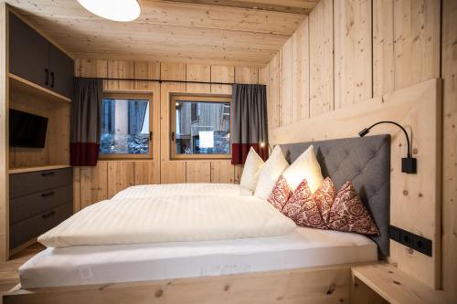 sypialnia z łóżkiem w drewnianym pokoju w obiekcie Stadl Lofts Plattenalm - Premiumchalets - Zillertal - Tirol - Salzburg w mieście Krimml