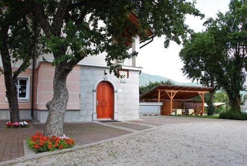 a small pink and white building with a red door at Prenočišča Angelin hram, Tiny Apartments in Markovec