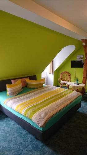 a bedroom with a large bed with a green wall at Restaurant Rosengarten in Neuruppin