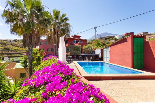 a villa with a swimming pool and purple flowers at Finca La Gaviota - Maxi in Icod de los Vinos