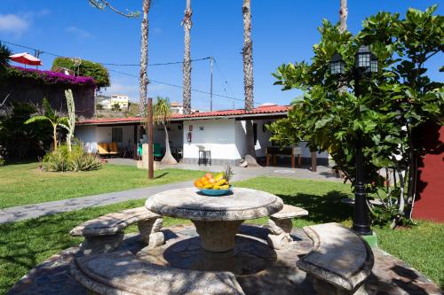 a table in a yard with a bowl of fruit on it at Finca La Gaviota - Maxi in Icod de los Vinos