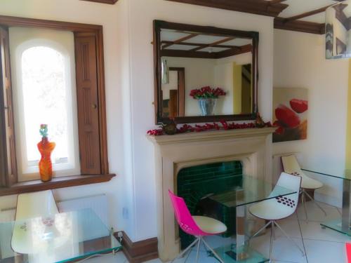 a dining room with a glass table and a fireplace at Godalming Hotel Guest House in Godalming