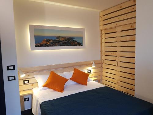 una camera con un letto con due cuscini arancioni di InCentro B&B a Milazzo
