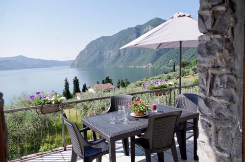 a table and chairs on a balcony with a view of a lake at Casa Emilia in Riva di Solto