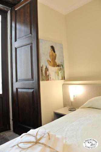 a bedroom with a bed and a painting on the wall at La Dimora del Musicante HomeGallery in Viggiano